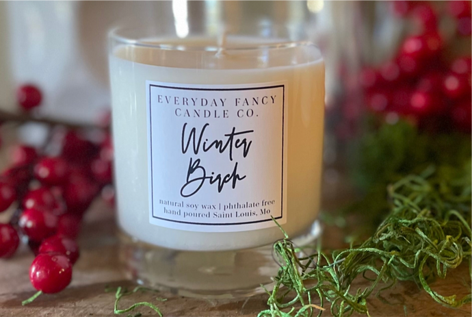 A holiday soy candle with a clear glass jar. The candle blends the refreshing scents of pine, fir, and clove with subtle smoky undertones, enhanced by sweet tonka and cranberry. Its cypress-fir fragrance evokes cozy winter memories, perfect for the holiday season.